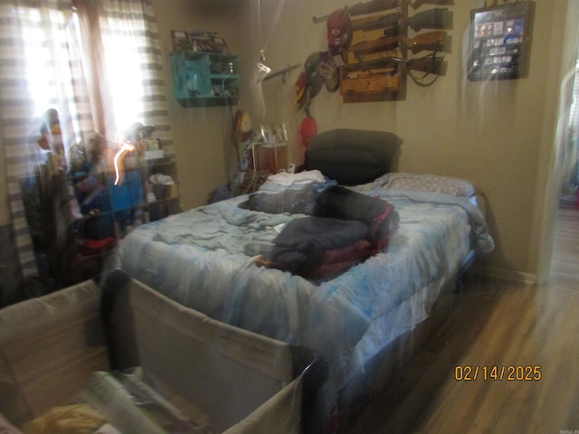 bedroom featuring baseboards and wood finished floors