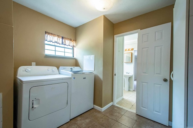 laundry room with laundry area, light tile patterned floors, baseboards, and separate washer and dryer