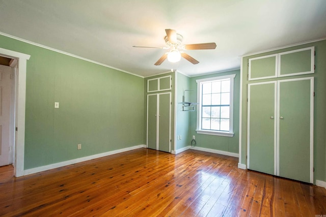 unfurnished bedroom with ornamental molding, ceiling fan, baseboards, and hardwood / wood-style flooring