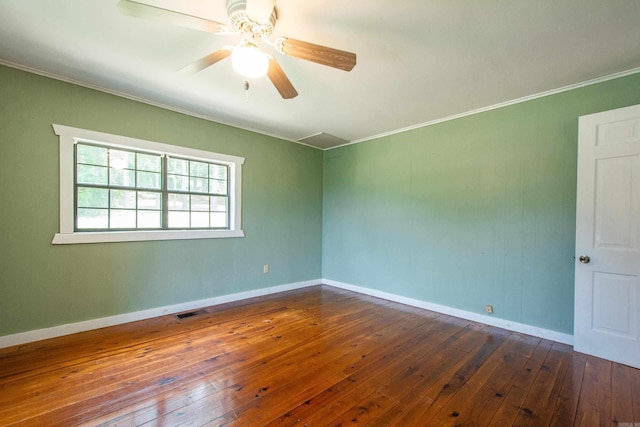 spare room with dark wood-style floors, baseboards, visible vents, and a ceiling fan