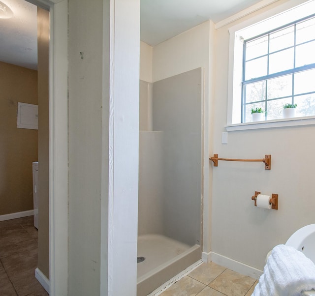 full bathroom with a shower stall, baseboards, and tile patterned floors