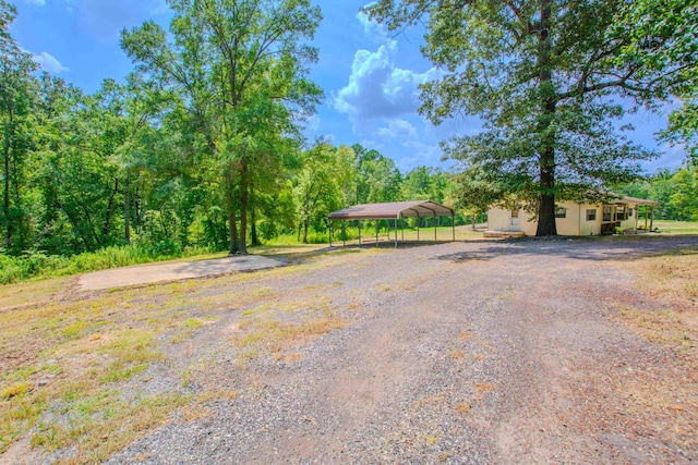 view of yard featuring gravel driveway and a carport