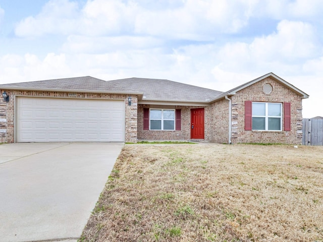 single story home featuring an attached garage, driveway, a front yard, and brick siding