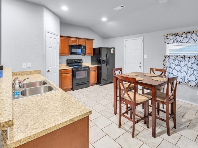 kitchen featuring black appliances, a sink, light countertops, and brown cabinets