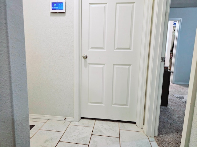 hall with baseboards and a textured wall