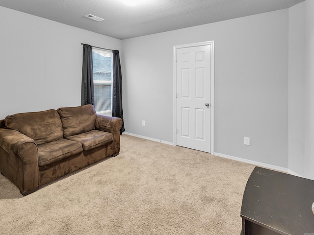 living room featuring a textured ceiling, carpet floors, visible vents, and baseboards