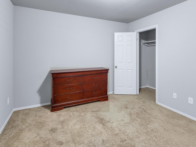 unfurnished bedroom featuring carpet floors, a textured ceiling, and baseboards