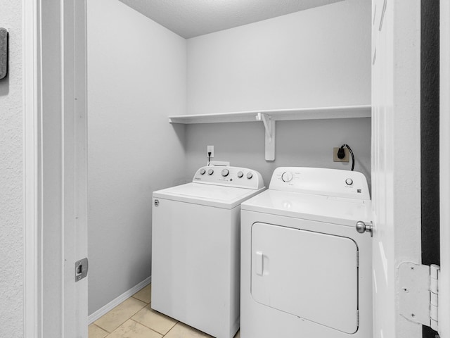 laundry room featuring laundry area, baseboards, a textured ceiling, and independent washer and dryer