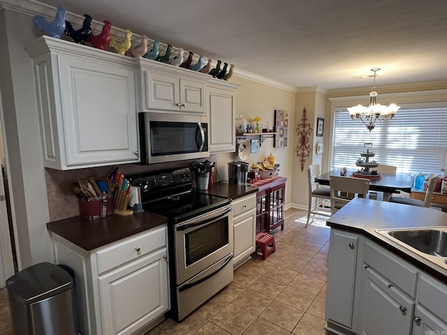 kitchen featuring crown molding, light tile patterned floors, stainless steel appliances, dark countertops, and white cabinets