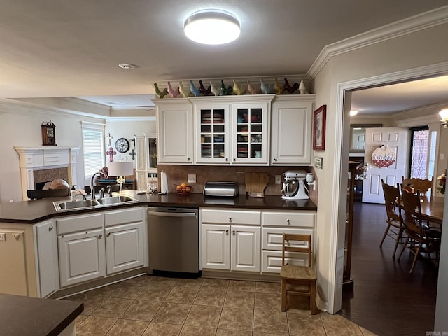 kitchen with a sink, dark countertops, crown molding, and dishwasher