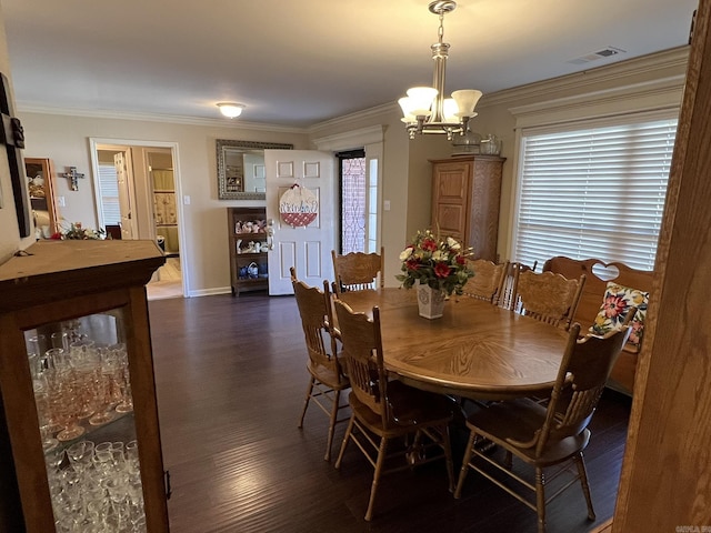 dining area featuring an inviting chandelier, visible vents, ornamental molding, and dark wood-style flooring