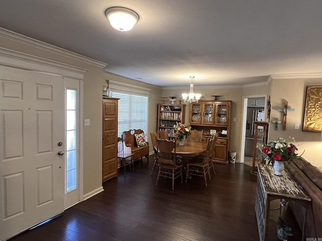 dining space with ornamental molding, a chandelier, and dark wood finished floors