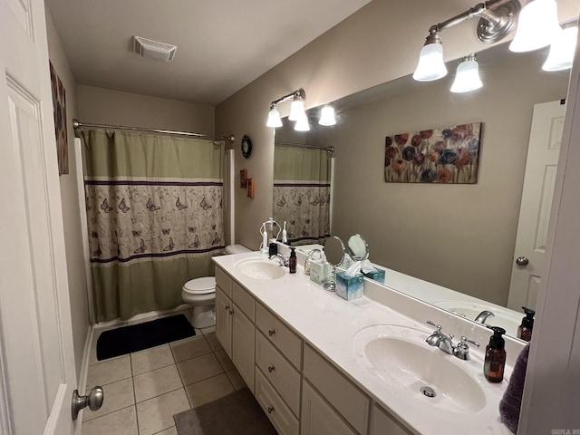 bathroom featuring toilet, visible vents, a sink, and tile patterned floors