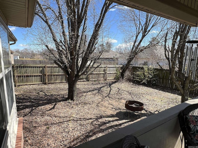 view of yard with a fenced backyard and a fire pit