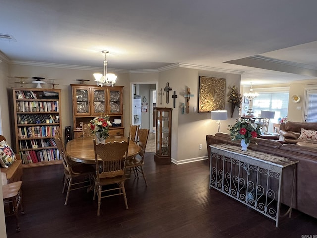 dining space with crown molding, dark wood finished floors, visible vents, and an inviting chandelier