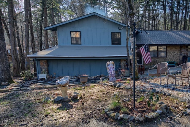 view of front of home featuring roof with shingles, a patio, and brick siding