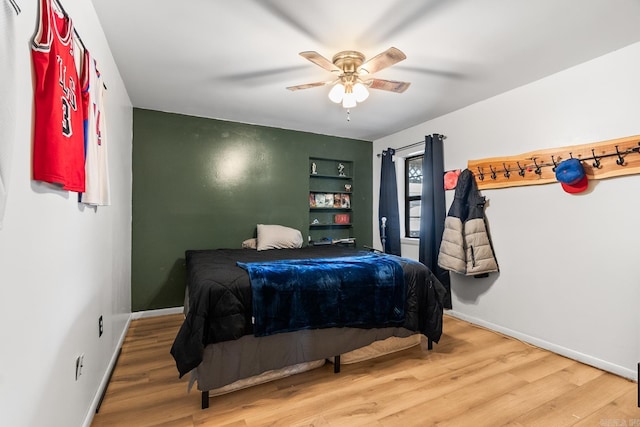 bedroom with a ceiling fan, baseboards, and wood finished floors