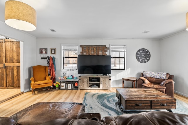 living area with a wealth of natural light, wood finished floors, and visible vents