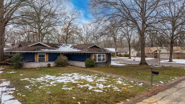 view of front of house with brick siding and a lawn