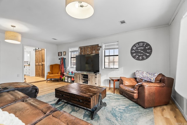 living room with visible vents, ornamental molding, and wood finished floors