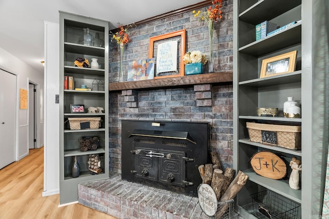 living area with baseboards, a fireplace, wood finished floors, and built in features