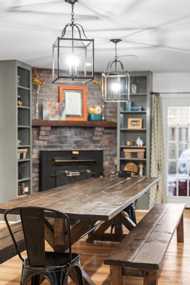 dining room featuring a fireplace and wood finished floors