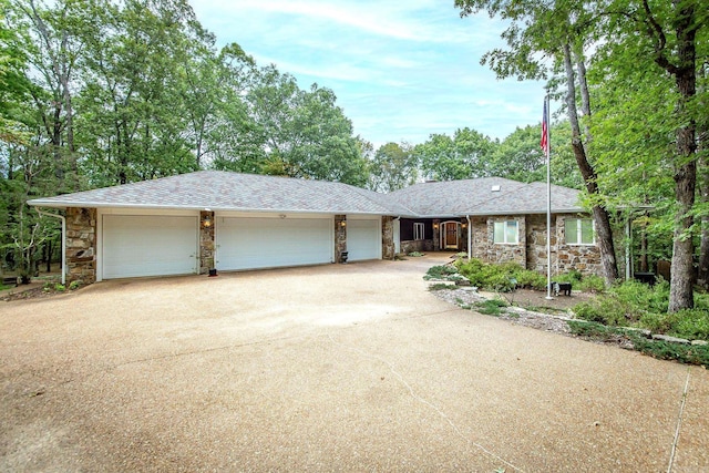 ranch-style home featuring a shingled roof, stone siding, driveway, and an attached garage