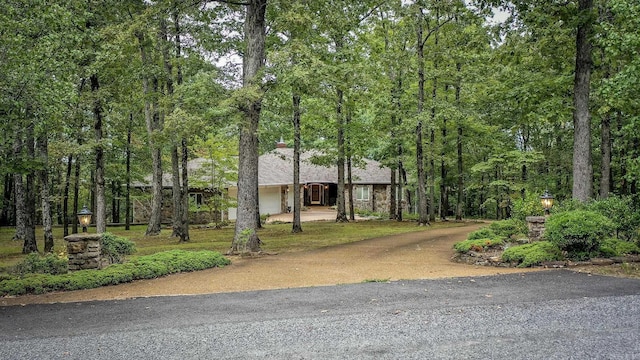 view of front of property featuring a wooded view