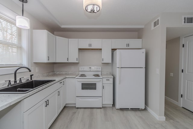 kitchen with white appliances, visible vents, a sink, and white cabinetry