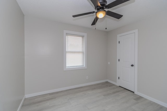 empty room with light wood-style flooring, baseboards, and ceiling fan