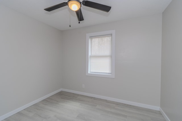 empty room featuring a ceiling fan, baseboards, and light wood finished floors