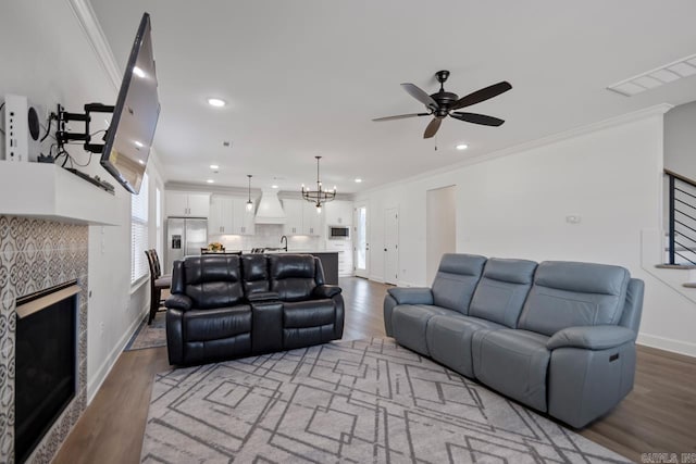 living area with ornamental molding, stairway, and wood finished floors