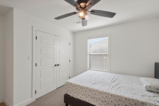 carpeted bedroom featuring ceiling fan, a closet, visible vents, and baseboards