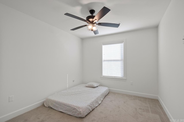 carpeted bedroom featuring baseboards and a ceiling fan