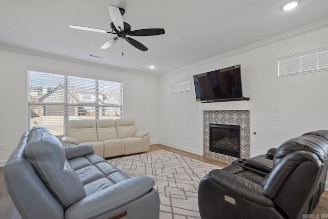 living room with baseboards, a fireplace, and crown molding