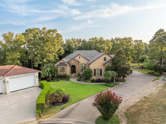 view of front of house with a garage, driveway, stone siding, stucco siding, and a front lawn