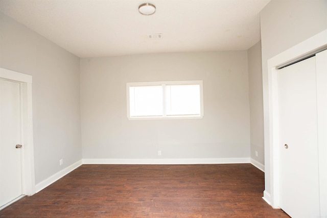 unfurnished bedroom featuring wood finished floors and baseboards