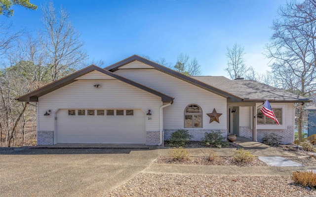 view of front of property with driveway, a garage, and brick siding