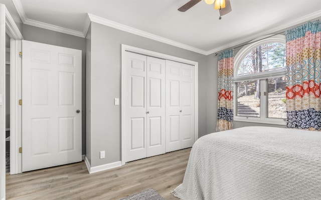 bedroom featuring ornamental molding, a closet, baseboards, and wood finished floors