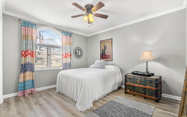 bedroom featuring ornamental molding, baseboards, and wood finished floors