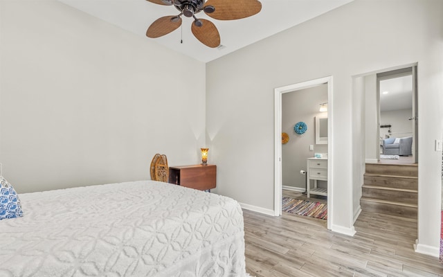 bedroom with ensuite bath, wood finished floors, a ceiling fan, and baseboards