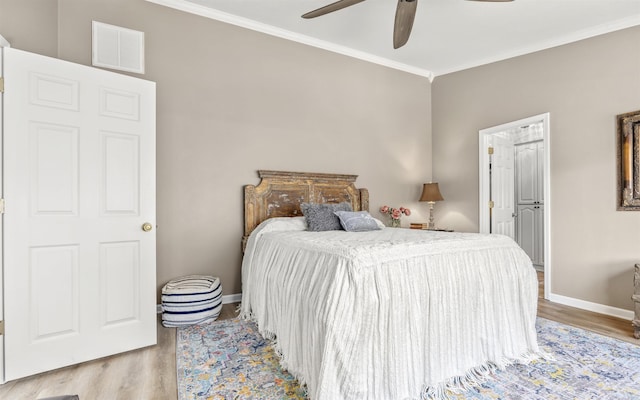 bedroom featuring ornamental molding, wood finished floors, visible vents, and baseboards