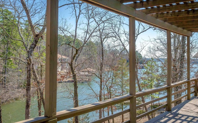 wooden terrace featuring a water view, a forest view, and a pergola