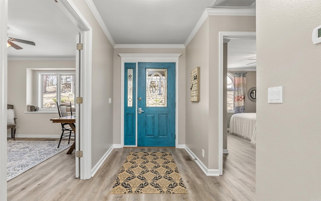 entryway with ornamental molding, wood finished floors, and visible vents