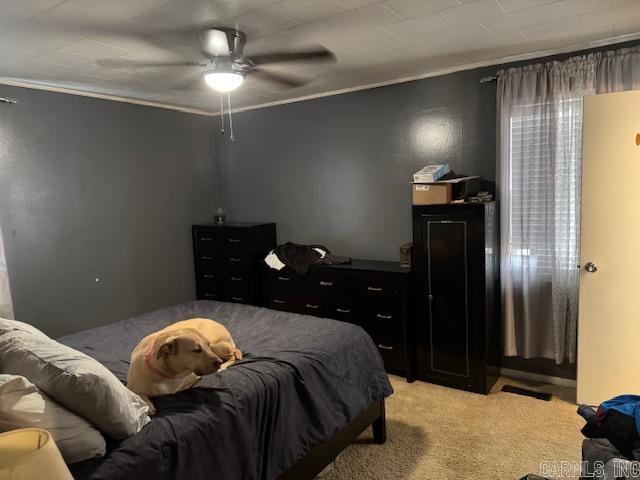 bedroom with ceiling fan, ornamental molding, and light colored carpet