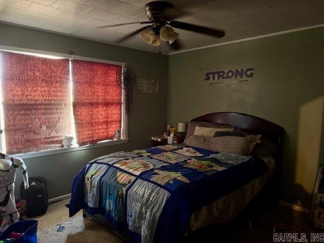 carpeted bedroom with ornamental molding and a ceiling fan