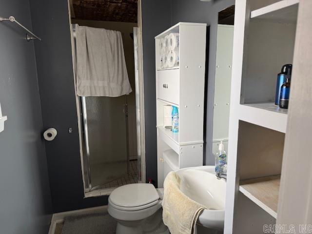 bathroom featuring toilet and a shower stall