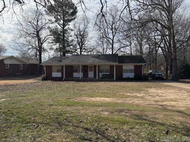 view of front facade with dirt driveway and a front yard