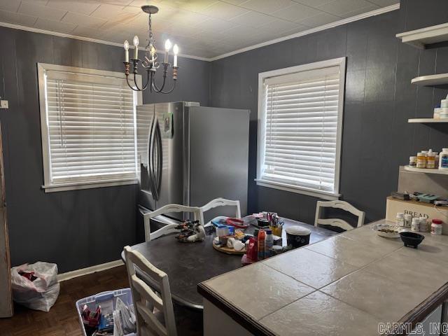 kitchen featuring a notable chandelier, tile counters, freestanding refrigerator, open shelves, and crown molding