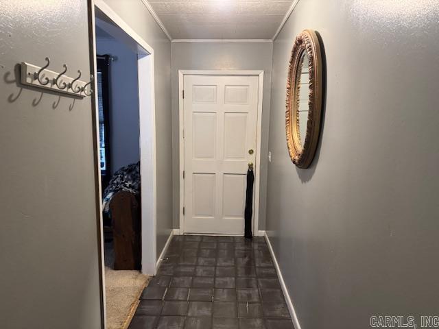 doorway to outside featuring baseboards and crown molding